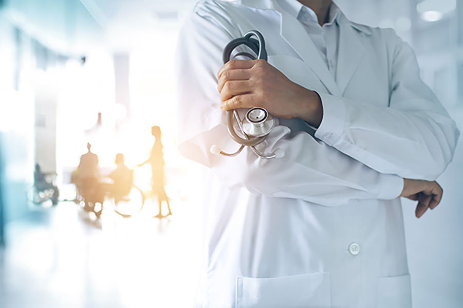 A doctor in a white medical coat holding a stethoscope